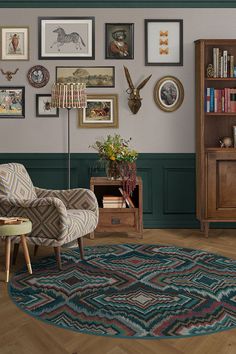 a living room filled with furniture and lots of framed pictures on the wall next to a book shelf