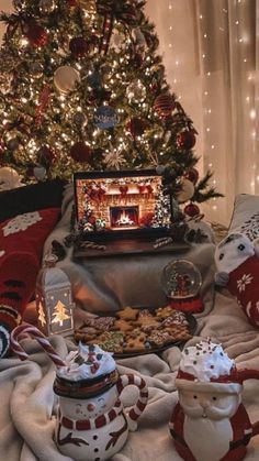 a christmas tree with lights and presents in front of it