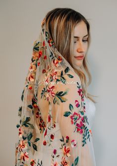 a woman wearing a veil with flowers on it