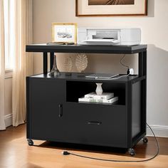 a printer is sitting on top of a black cabinet