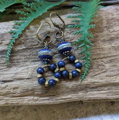 These royal blue leverback earrings feature a bounty of vintage wooden beads, antiqued brass, and lush handcrafted glass art beads. Each art bead- like each piece of jewelry in my shop- is created one at a time by the artisan. The royal blue and brass make an eye-catching and classic combination; great for everyday wear and effortless beauty. The wood and brass beads can move freely around the brass hoops, which adds whimsy, and makes them fun to play with :). These boho lovelies would make a treasured gift for the eclectic, artsy, boho, free spirited, lover of blue, one of a kind friend or loved one in your life! All the details, below: *Earrings measure 1 and 5/8 inches from the base of the ear wire *Lever back ear wires are made in the USA of lead/nickel free antiqued brass *Lampworked Vintage Metal Beaded Earrings For Gift, Vintage Beaded Earrings As Gift, Vintage Adjustable Beaded Earrings For Gift, Vintage Brass Beaded Earrings For Gifts, Vintage Brass Beaded Earrings Gift, Vintage Beaded Earrings With Ear Wire As Gift, Vintage Dangle Beaded Earrings As Gift, Vintage Dangle Beaded Earrings For Gift, Vintage Beaded Dangle Earrings For Gift