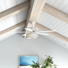 a living room filled with furniture and a painting on the wall next to a ceiling fan