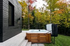 a hot tub sitting on top of a lush green field next to a wooden building