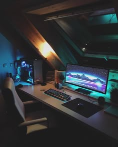 a desktop computer sitting on top of a desk under a slanted ceiling in an attic