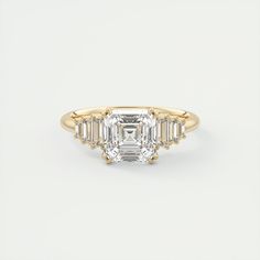 an emerald cut diamond ring with baguetts in yellow gold