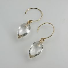 Clear Quartz Teardrop with Gold Dangle Earrings  Crystalline clear, micro- faceted AAA quality clear natural Quartz teardrop briolette gemstones stand out in these simply charming and elegant earrings. They are paired with arced gold earring hooks.  The earrings are approximately 1 1/4 inches long from the top of the gold earring to the bottom of the inverted pear Quartz briolettes. The briolettes are approximately 9mm X 14mm. The earrings are gold-filled. Earring stopples are included to keep your earrings secure.  This piece is a one-of-a-kind design, handmade by me. Check the Shop Policies page for purchase and shipping details. Personal Treasures - designer gemstone jewelry by Phyllis Mufson. To find a wide selection of more casual jewelry check out my Mufi Jewels store - http://www.et Gold Dangle Earrings, Casual Jewelry, Gold Earring, Pearl Charms, Bar Earrings, Lovely Earrings, Earring Hooks, Stunning Necklace, Gold Earrings Dangle