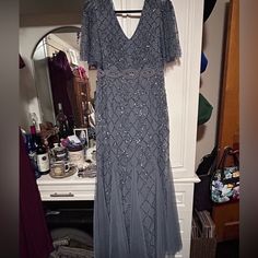 a dress is hanging on a rack in a room next to a dresser and mirror