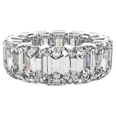 an emerald cut diamond ring with three rows of diamonds on the side and four rows of round