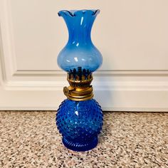 a blue vase sitting on top of a counter next to a white wall and door