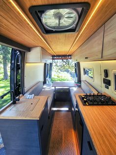 the inside of a camper with wood counter tops and cabinets on either side of the kitchen