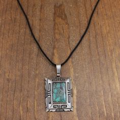 Sterling silver bold pendant. 1 7/8" tall x 1 1/2" wide. The ring and bail add13/16" to the height. The back is signed W Denetdale ( Will Navajo). The pendant is 36.1 grams. The turquoise is 1" tall. It has very pretty matrix. A 30" black cloth cord is included. The necklace is in good condition. Thank you for shopping in our store. Please let us know if you have questions.  NECK-2133K-MS-5 k *The color you see on your screen may not reflect the actual stone color due to variations in monitors* Tucson Az, Cord Necklace, Turquoise Stone, Tucson, Geometric Design, Sterling Silver Pendants, Matrix, Pendant Necklaces, Stone Color