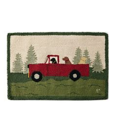 a door mat with a red truck and dog in the bed on top of it