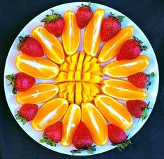 a white plate topped with sliced up oranges and strawberries