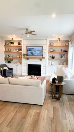 a living room filled with furniture and a flat screen tv mounted on the wall above a fireplace