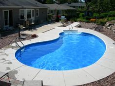 a backyard with a pool and patio furniture