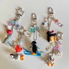 a collection of key chains with various charms attached to them on a white table top