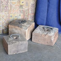 three wooden boxes sitting next to each other on the ground near a blue wall and rug