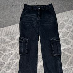 Never Worn, Dark Black Color, Pockets On Side Would Fit A Size 25-26 Black Mid-rise Grunge Pants, Black High Rise Grunge Pants, Black High Rise Baggy Cargo Jeans, Black Baggy High-rise Cargo Jeans, Black Mid-rise Grunge Cargo Jeans, High Waist Black Cargo Jeans, Black Grunge Straight Leg Cargo Jeans, Black Denim Casual Cargo Pants, Black Cargo Style Grunge Pants