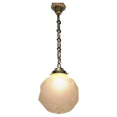 a light fixture with a chain hanging from it's end and a white glass ball on