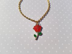 "this classy red rose bracelet would be a lovely gift for someone special! this delicate charm bracelet is made using a gold plated enamel pendant hung from gold plated chain.  total length of chain measures approx. 7\" and fastens with a lobster clasp fastener.  rose charm measures approx. 23mm x 13mm" Gold Flower Bracelets With Rose Design, Gold Floral Bracelets With Rose Design, Gold Flower Bracelet With Rose Design, Rose Gold Bracelet With Rose Design For Gift, Gold Bracelet With Rose Design For Gift, Valentine's Day Gift Bracelet With Rose Design, Rose Gold Flower Charm Bracelet As Gift, Rose Colored Bracelets For Valentine's Day Gift, Rose Jewellery