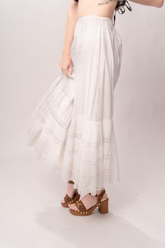 Enchanting Edwardian 1910’s white cotton petticoat maxi skirt with tiered tatted lace, a full skirt, and drawstring waist. Great vintage condition, with normal wear and condition for its age. Some faint spots and visible mending. Best fits modern size S/M Length 37”Waist up to 30” Featured top is the Gingham Graham Top from our friends at Psychic Outlaw. Model’s Measurements:Height 5’9”Chest 34”Waist 29”Hips 36.5” White Cotton Skirt With Attached Cancan, Vintage White Gathered Skirt Bottoms, Summer Maxi Length Bottoms With Lace Trim, Summer Maxi Bottoms With Lace Trim, Long Cotton Skirt With Lace Trim, Cotton Long Skirt With Lace Trim, Daywear White Ruffled Maxi Skirt, Lace Trim Maxi Skirt For Wedding, Flowy Wedding Maxi Skirt With Lace Trim