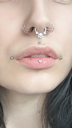 a woman with piercings on her nose and nose ring in front of her face