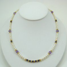 "This very pretty necklace is designed with white pearls, amethyst, purple velvet colored Swarovski Crystals, 18k Vermeil spacer beads, 24k Vermeil wire and a 24k Vermeil clasp.  The matching earrings are EV6.  Measures 18-1/2\" in length." Purple Pearl Single Strand Jewelry, Elegant Single Strand Amethyst Beaded Necklace, Purple Single Strand Pearl Jewelry, Gold Amethyst Single Strand Jewelry, Gold Amethyst Single Strand Necklace, Handmade Elegant Purple Pearl Necklace, Purple Pearl Single Strand Necklace, Elegant Handmade Amethyst Pearl Necklace, Purple Single Strand Pearl Necklace