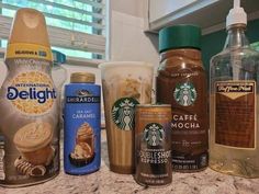 there are many different types of coffee drinks on the counter top, including one with ice cream and two with caramel