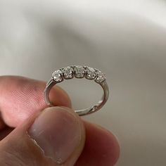 a person holding a ring with three diamonds on it