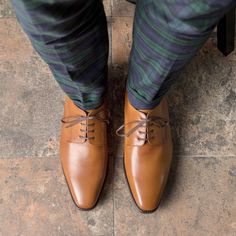 a person wearing brown shoes and green pants