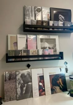 two black shelves filled with books on top of a white counter