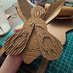 someone is making a paper bird out of cardboard