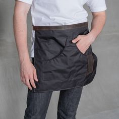 a man wearing an apron with his hands on his hips and holding the back pocket open