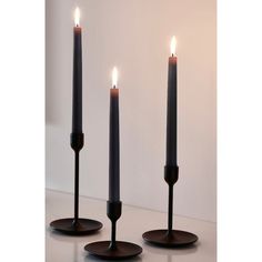 three black candles sitting on top of each other