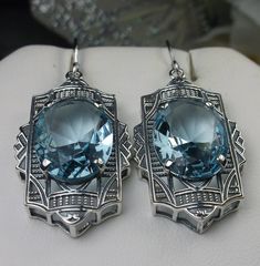 "Simulated Aquamarine Earrings Braid Design#E19 Custom Made Inspired by the Art Deco movement of the early 1900s, I now offer these lovely Antique reproduction earrings in sterling silver. Each stunning 8ct flawless Simulated Blue aquamarine is 16mm long (just over 5/8th\") and 12mm in width (1/2\"). The aquamarines have perfect color and clarity. The earrings are 1 3/4th inches long. Notice the beautiful design of the Deco filigree setting. These earrings were fashioned from an Art Deco 1930s b Oval Art Deco Earrings For Formal Occasions, Art Deco Oval Earrings For Formal Occasions, Art Deco Hallmarked Drop Earrings, Formal Oval Art Deco Earrings, Hallmarked Art Deco Earrings For Anniversary, Handmade Art Deco Jewelry For Anniversary, Art Deco Sterling Silver Earrings For Formal Occasions, Art Deco Pierced Jewelry For Anniversary, Art Deco Hallmarked Earrings As Gift