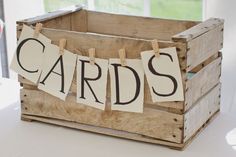 a wooden crate with clothes hanging from it's sides and the words cards on them