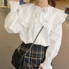 Long sleeve blouse with an oversized peter pan collar with frilly edges. Double layers. Frilly elastic cuffs. 100% polyester S: 18.5" across shoulders, 40" chest, 25" length M: 19" across shoulders, 41.5" chest, 25.5" length L: 19.5" across shoulders, 43" chest, 26" length XL: 20" across shoulders, 44.5" chest, 26.5" length White Shirt Outfits, Frilly Blouse, Shirt Outfits, White Collared Shirt, Double Collar, Blouse Outfit, Pan Collar, Peter Pan Collar, Shirt White