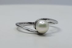 This is a lovely white freshwater pearl ring, stamped 925 sterling silver with an Avon makers mark Pearl, the birthstone of June, is often the gemstone associated with the third wedding anniversary.  A pearl is composed of calcium carbonate formed in the mantle of a shelled mollusk, such as an oyster.  A pearl is created as layers of nacre, otherwise known as mother of pearl, adhere over time. The surface of a genuine pearl will generally be pulverent, a gentle roughness to the touch revealing this process. The pearl gem inspires introspection and cultivates wisdom as we seek connection to ourselves and to the universe.  Pearl is known for restoring and invigorating the Sacral, Heart and Crown Chakras.  The pearl signifies wisdom, experience and integrity. Pearls are extremely soft and fra Elegant White Hypoallergenic Pearl Ring, Hypoallergenic Round Pearl Ring For Anniversary, Hypoallergenic Pearl Ring For Anniversary, Third Wedding Anniversary, 3rd Anniversary, Freshwater Pearl Ring, Les Chakras, Vintage Pearl, Calcium Carbonate