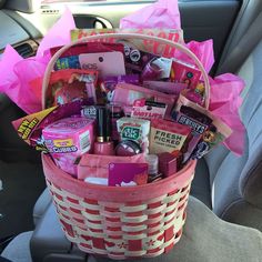 a pink basket filled with lots of items in the back seat of a car,