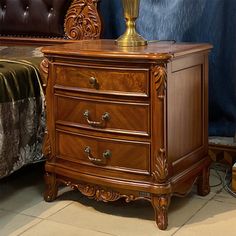 a bed room with a neatly made bed and a night stand on the floor next to it