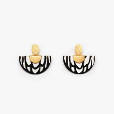 two pairs of earrings with black and white designs on the front, one in gold