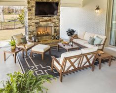 a living room with furniture and a fire place in front of a brick wall that has a screen on it