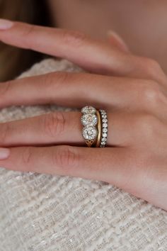 a woman's hand with two rings on her finger and one ring in the middle