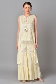 Ivory asymmetric kurta with floral embroidered motifs and front tassel tie-up. Paired with tiered and embroidered sharara.
Component: 2
Embroidered
Neckline: Round
Sleeve Length: Sleeveless
Fabric: Cotton Chiffon
Color: White
Front tassel tie-up - Aza Fashions Elegant Chikankari Embroidered Top For Wedding, Off White Floral Embroidered Sharara For Reception, Traditional Cream Sharara With Floral Embroidery, Elegant Summer Sharara With Intricate Embroidery, Intricate Embroidery Palazzo Set For Summer Wedding, Intricate Embroidered Palazzo Set For Summer Wedding, Embroidered Palazzo Set For Summer Wedding, Summer Wedding Palazzo Set With Chikankari Embroidery, Bohemian Floral Embroidered Top For Wedding