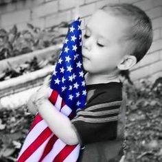 a young boy holding an american flag in his hands