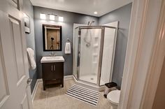 a bathroom with a shower, toilet and sink in it's corner stall area