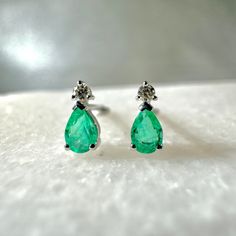 "A timeless and elegant design, symbolizing wealth and harmony. Perfect for everyday wear or dressed up for special occasions. Add a pop of color with our Genuine Emerald and Diamond Teardrop Stud Earrings, available in 14k solid white gold and 14k solid yellow gold. Item Specifications: Materials: 14k Solid Gold  Gemstone: Natural Emerald Stud Diameter: 6 mm x 3 mm  Earring Posts Length: 10-11 mm  Total Gold Weight: 0.64 ct. Total Emerald Weight: 0.28 ct. Total Diamond Weight: 0.03 ct. Diamond Classic White Gold Earrings With Timeless Design, Timeless Design Round Earrings For Gift, Classic White Gold Emerald Diamond Earrings, Classic White Gold Earrings, Classic Sterling Silver Earrings With Timeless Design, Elegant Earrings With Timeless Design As Gift, 14k Gold Earrings For Anniversary With Timeless Design, Elegant Timeless Design Earrings As Gift, Elegant Gift Earrings With Timeless Design