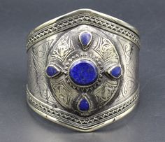 "Vintage Turkmen traditional alpaka bracelet. Its 100% hand crafted workmanship with beautiful Lapis Lazuli stone and lovely carved design. Please do not hesitate to contact if you have any questions. Weight : 68.1 grams, Opening of the mouth : 1.6\" ( 4 cm ) Inner circumference : 15 cm ( 5.9\" ) Width : 7cm ( 2.8\" ) Please know what you are bidding on. The metal of Most Kuchi, Afghan and Turkoman items are called with different names, Some called Alpaca silver, German Silver and Tibetan Silver Artisan Cuff Bracelet As Festival Gift, Artisan Bangle Cuff Bracelet For Festivals, Traditional Blue Adjustable Cuff Bracelet, Traditional Blue Bangle For Festivals, Bohemian Bracelet For Ceremonial Festivals, Traditional Bangle Bracelet For Festivals, Handmade Bohemian Bracelets For Festival, Bohemian Cuff Bracelet For Festivals Gift, Adjustable Cuff Bracelet For Ceremonial Festivals