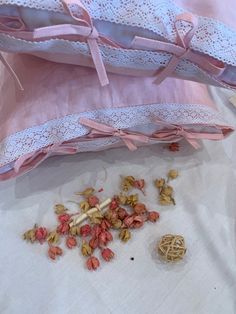 the contents of a pink purse are scattered on top of a white sheeted surface