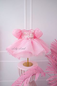 This beautiful Pink Pearls Flower Girl Dress is perfect for any special occasion, including infant first birthdays, weddings, pageants, and other special events. The dress features a stunning pink tutu skirt that will make your little princess feel like a true fairy tale character. The top is adorned with delicate pearls, adding a touch of elegance and sophistication to the design. Crafted with the utmost care and attention to detail, this dress is made of high-quality materials that are soft, c Princess Tutu Dress With Floral Applique For Birthday, Princess Style Tutu Dress With Floral Applique For Birthday, Spring Princess Pageant Dress For Birthday, Spring Birthday Princess Pageant Dress, Sweet White Princess Dress For First Birthday, Princess Style Pageant Dress For Spring Birthday, Birthday Tutu Dress With Floral Applique, Princess Style Pink Ball Gown For Baptism, Pink Ruffled Ball Gown For Birthday